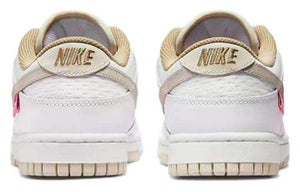 حذاء Nike Dunk Low رياضي باللون الأبيض والوردي.