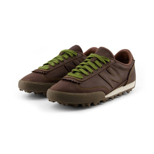 Donald Glover x New Balance RC30 "Golden Hour" low-top sneaker in brown leather colorway, three-quarter perspective displaying smooth leather uppers, contrast stitched details, olive green laces, and a unique studded rubber traction outsole.
