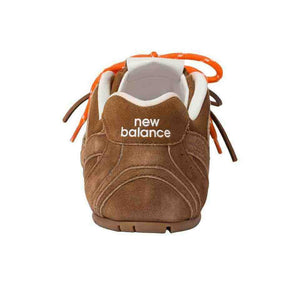 Front view close-up of brown suede New Balance x Miu Miu shoes with double-lacing detail.