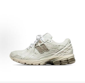 Lateral side profile view of cream and off-white New Balance shoes 1906R.