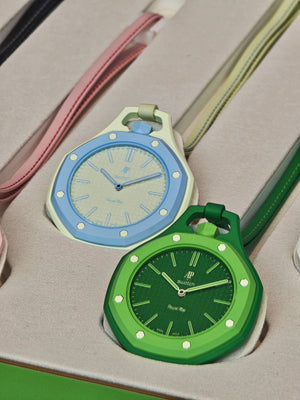 A close-up of a pastel green and a light blue Audemars Piguet x Swatch Royal Pop watches resting inside their custom display tray.