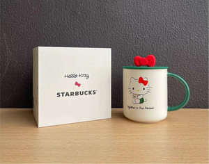 كوب Starbucks بتصميم Hello Kitty مع غطاء وقشة باللون الأخضر.