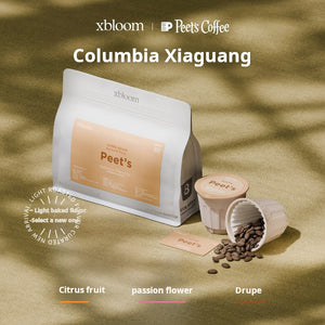 A promotional image featuring an XBloom Peet's Coffee bag and XBloom xpods coffee capsules, with 'Columbia Xiaguang' text at the top and color-coded flavor notes for Citrus fruit, passion flower, and Drupe at the bottom.