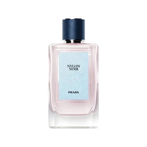 عطر برادا نسائي Black Nylon بزجاجة شفافة محاطة بزهور برتقالية وبيضاء