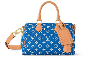 حقيبة Speedy 25 جلد باللون الأزرق ونقشة Monogram بيضاء.