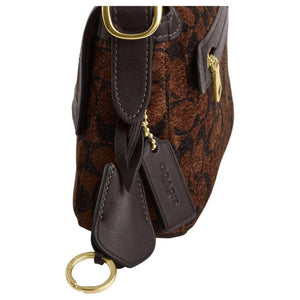 حقيبة كتف COACH بنقشة Signature المميزة باللون البني.
