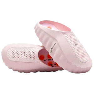 Angular view of a pair of Nike Mind 001 baby pink shoes, displaying the textured upper mesh structure and comfortable slip-on style.