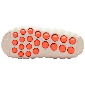 Bottom traction sole view of the Nike Mind 001 off-white, featuring rows of textured apricot orange grip pods for stability.