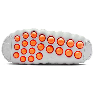 Full view of the Nike Mind 001 outsole showing the grid pattern of circular orange traction pods designed for impact absorption and grip.