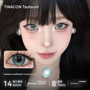 A close-up of a model wearing Tinacon Mermaid Blue contact lenses with 14.4mm diameter, showing the vibrant icy blue color on dark eyes.