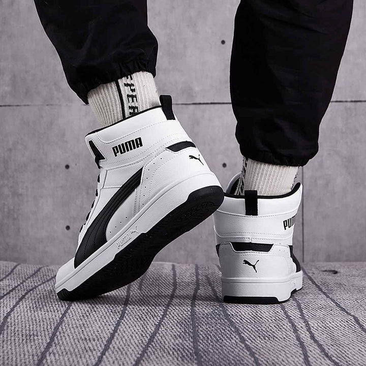 High-top Puma sneakers in classic white and black with ankle support and rubber sole, perfect for sporty fashion.