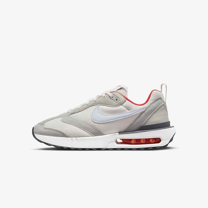 Nike Air Max Dawn running shoe with visible air cushioning, high-quality leather, mesh, and sporty gray, white, and red design.