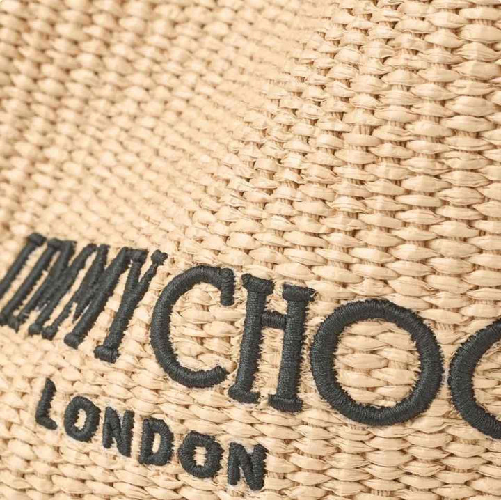Bag detail showing the Jimmy Choo London logo on woven fabric.