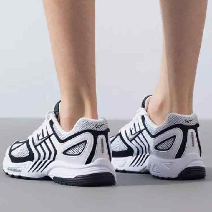 White and black Nike Pegasus 2K5 sneakers with sporty design, breathable mesh upper, full-length Nike Air cushioning, and durable outsole.