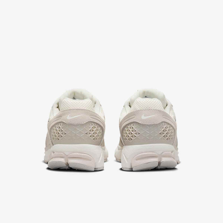 Nike Zoom Vomero 5 in ivory featuring mesh leather and geometric details, rear view.