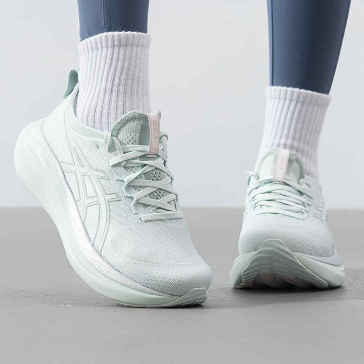 Light green ASICS Gel-Nimbus 27 shoes with innovative cushioning and mesh upper for comfort and style.