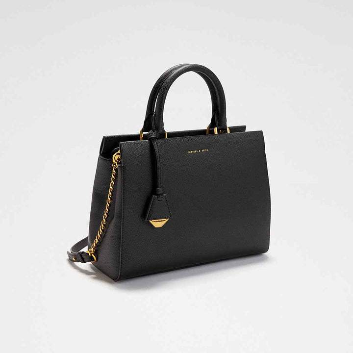 Black CHARLES&KEITH Mirabel top handle bag with gold accents, durable dual handles, adjustable strap, and secure zipper closure.