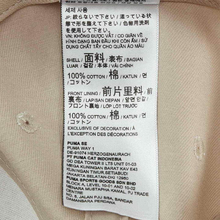 Puma unisex baseball cap tag with material details in multiple languages.