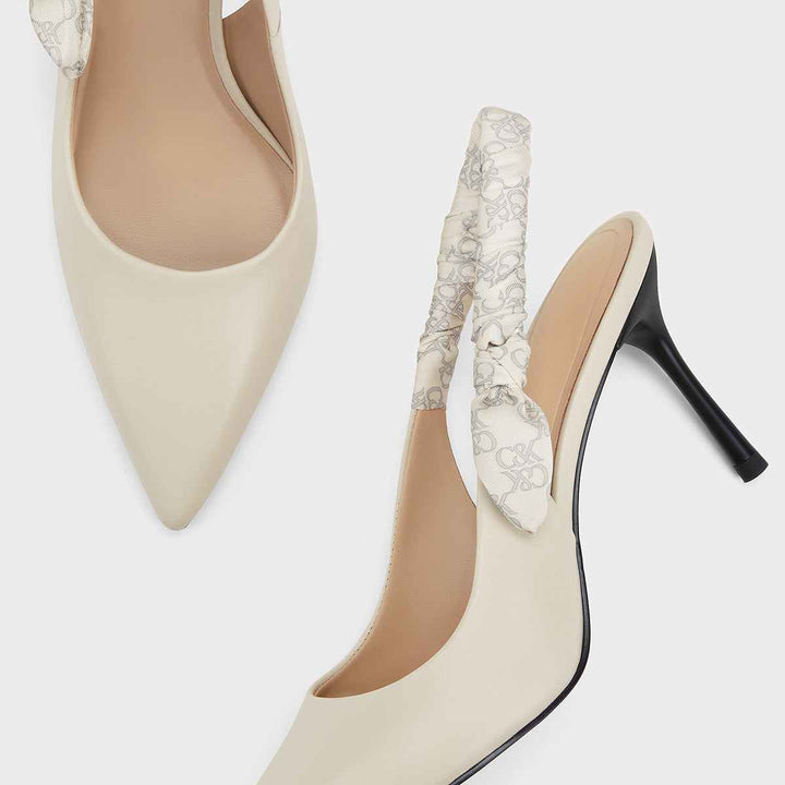 Elegant cream-colored high heels with a slim stiletto and patterned elastic strap by CHARLES&KEITH.