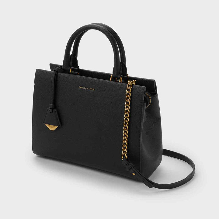 CHARLES&KEITH Mirabelle black top handle bag with gold accents, eco-friendly materials, and adjustable strap.