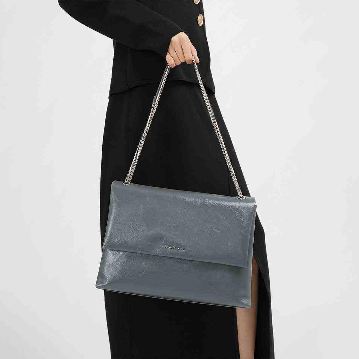 حقيبة كتف Charles & Keith بسلسلة معدنية ولون أزرق رمادي.