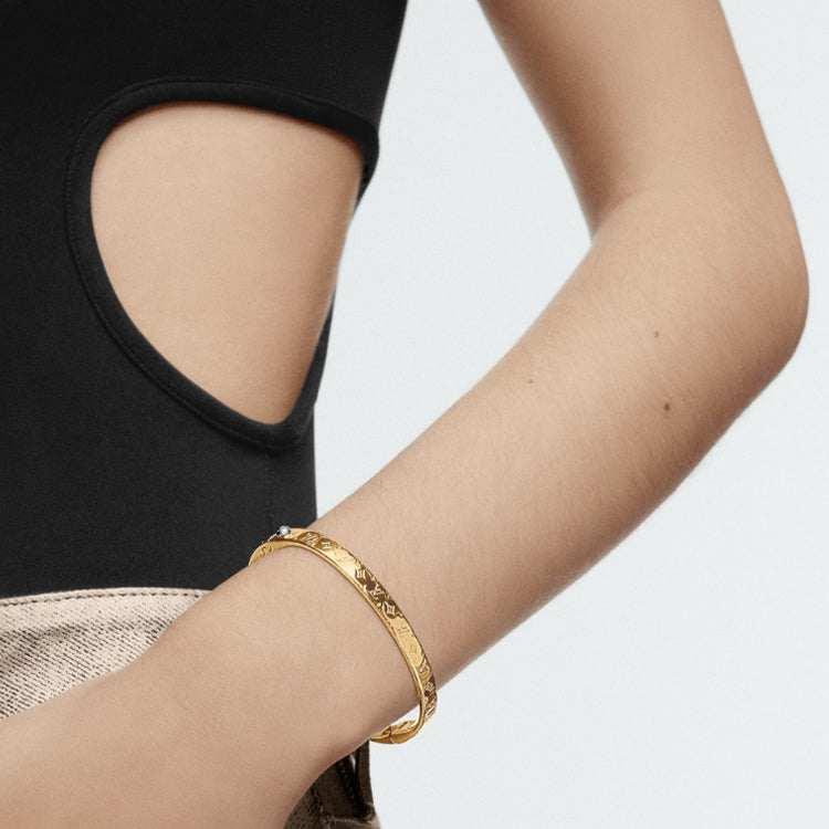 LOUIS VUITTON Logo engraved metal bracelet women's gold.
