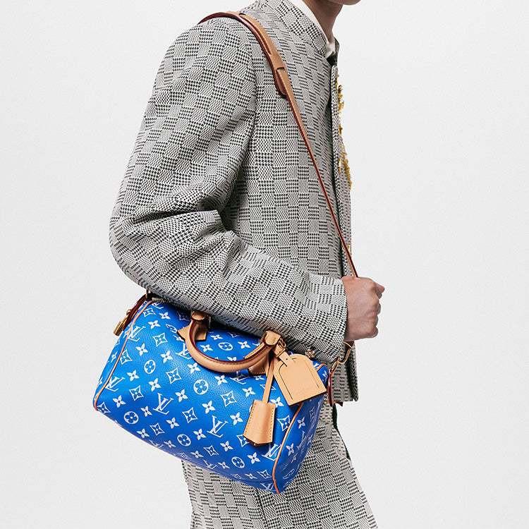حقيبة Speedy 25 جلد باللون الأزرق ونقشة Monogram بيضاء.