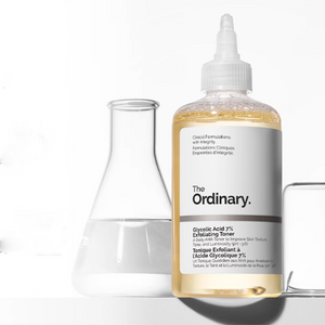 عبوة تونر الغلايكوليك بشعار The Ordinary بجانب أدوات مخبرية زجاجية