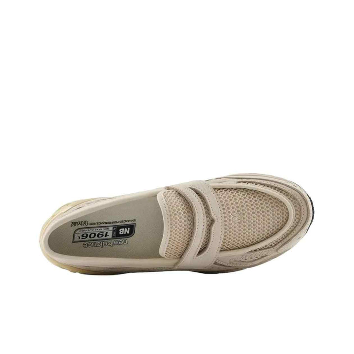 New Balance 1906 beige mesh and leather sneaker with cushioned sole and rounded toe design.
