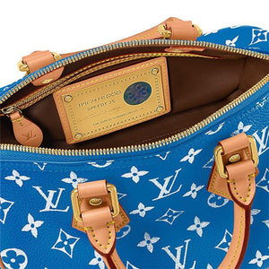 حقيبة Speedy 25 جلد باللون الأزرق ونقشة Monogram بيضاء.