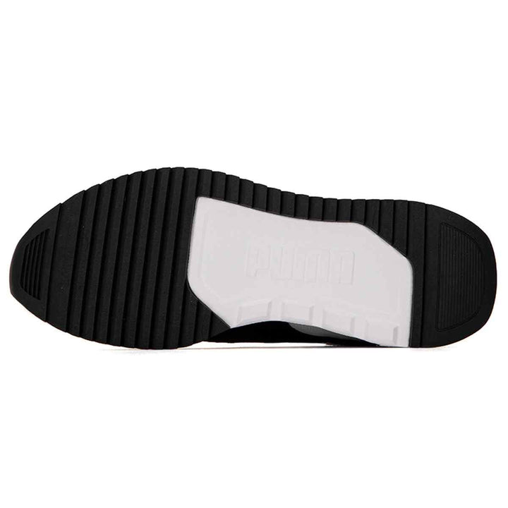 Bottom view of Puma Retro sneakers showcasing the black rubber sole with a white accent, designed for stability and movement.