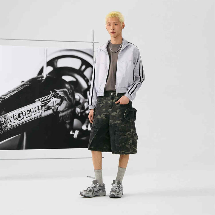 man wearing New Balance 1906R metallic silver sneakers with casual sporty outfit standing indoors