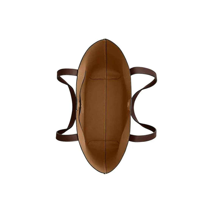 top view of empty brown leather Manhattan tote handbag by Coach with two handles and spacious interior for daily essentials organization