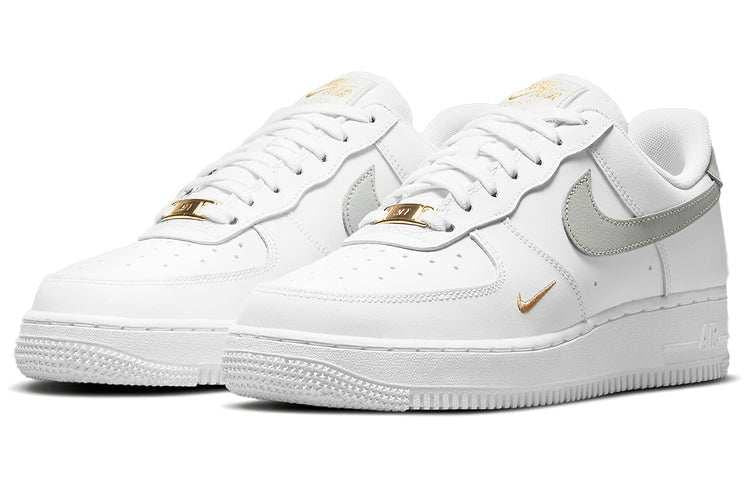 حذاء Nike Air Force 1 أبيض بتفاصيل رمادية وذهبية.