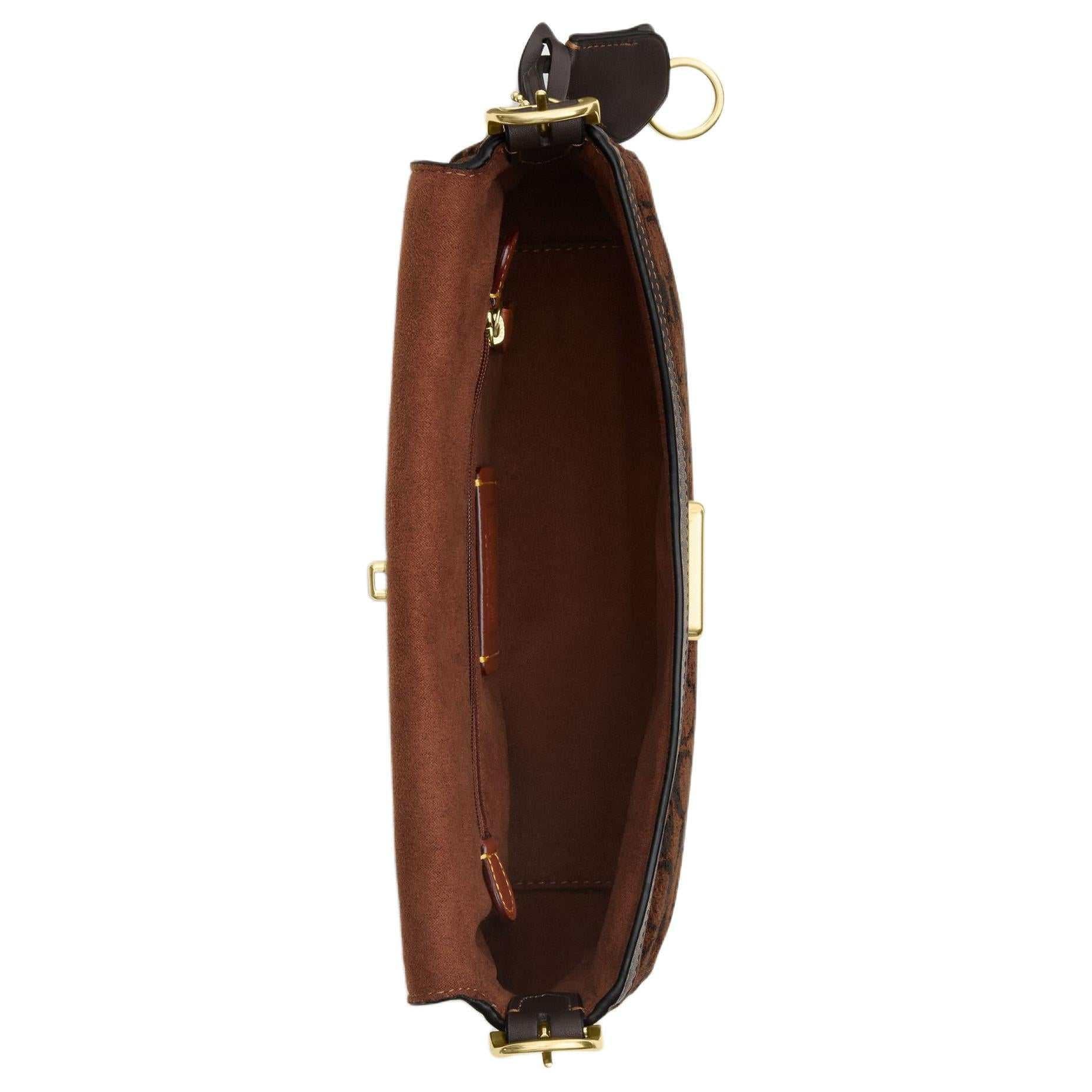حقيبة كتف COACH بنقشة Signature المميزة باللون البني.