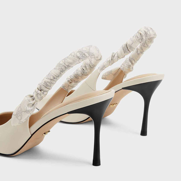 Elegant high heels with patterned elastic straps by CHARLES&KEITH in cream leather.