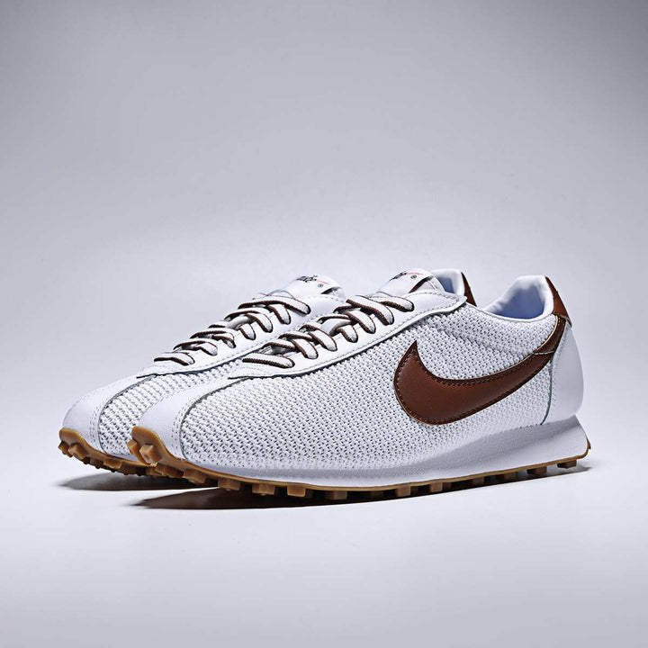 Pair of white Nike LD-1000 running shoes with brown swoosh logo and rubber soles