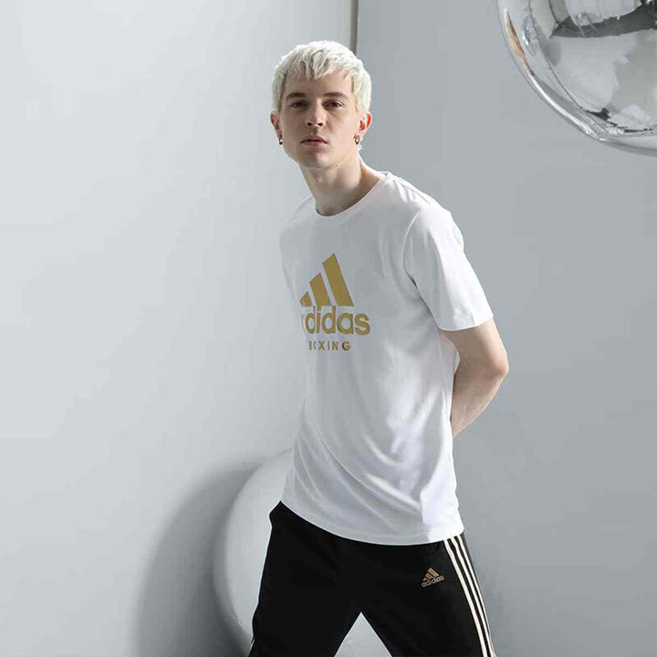 Men's adidas short sleeve white T-shirt with gold logo, casual sportswear.
