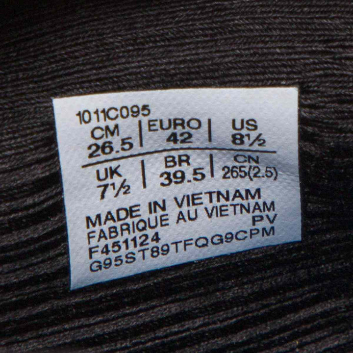 ASICS Gel-Nimbus 27 size label on black fabric background with manufacturing details.