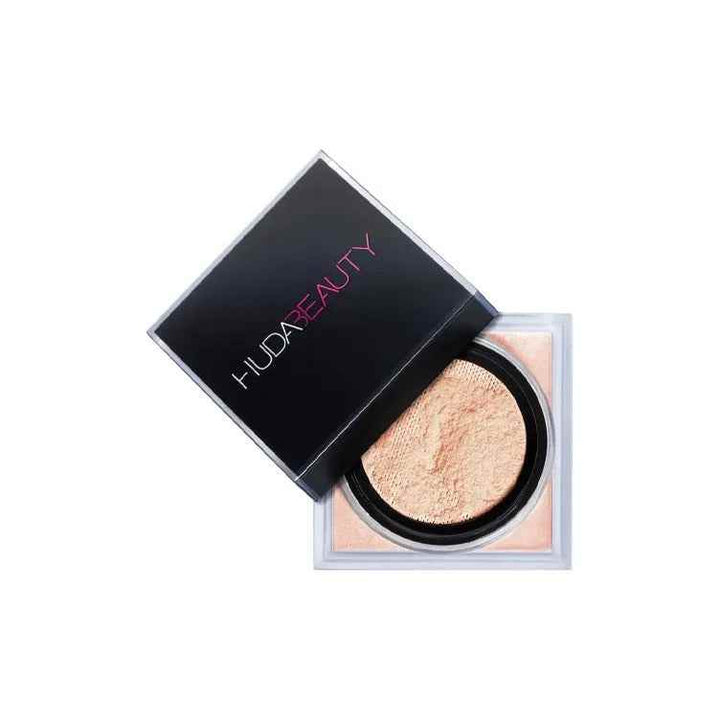 Huda Beauty Easy Bake Loose Powder in open black and transparent container with soft beige powder for natural luminous finish