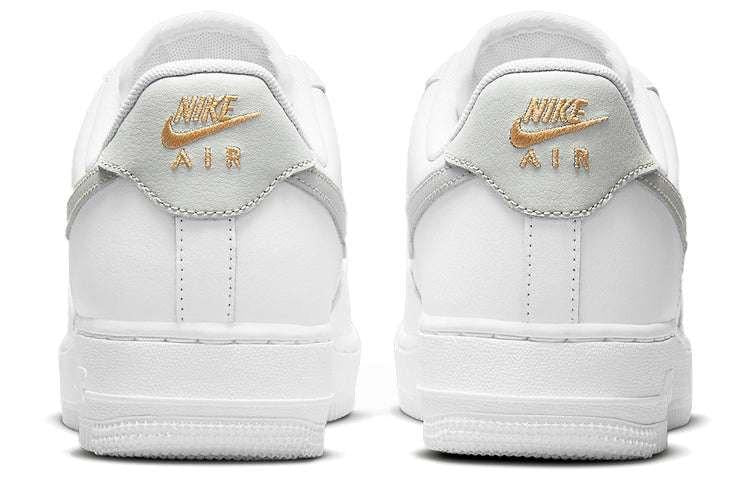 حذاء Nike Air Force 1 أبيض بتفاصيل رمادية وذهبية.