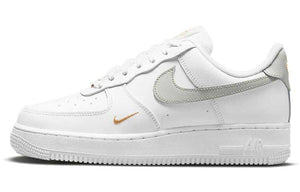 حذاء Nike Air Force 1 أبيض بتفاصيل رمادية وذهبية.