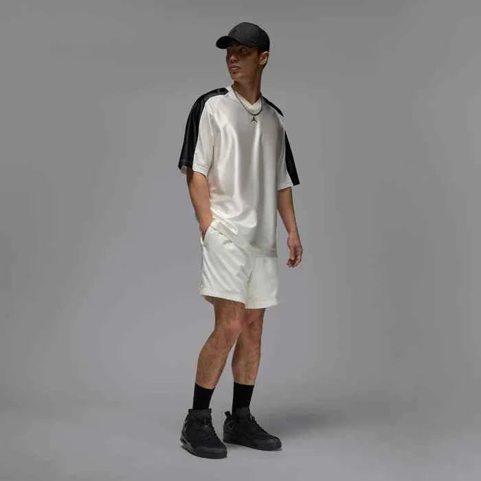 Man wearing black Air Jordan Spizike Low shoes with shorts and a cap.