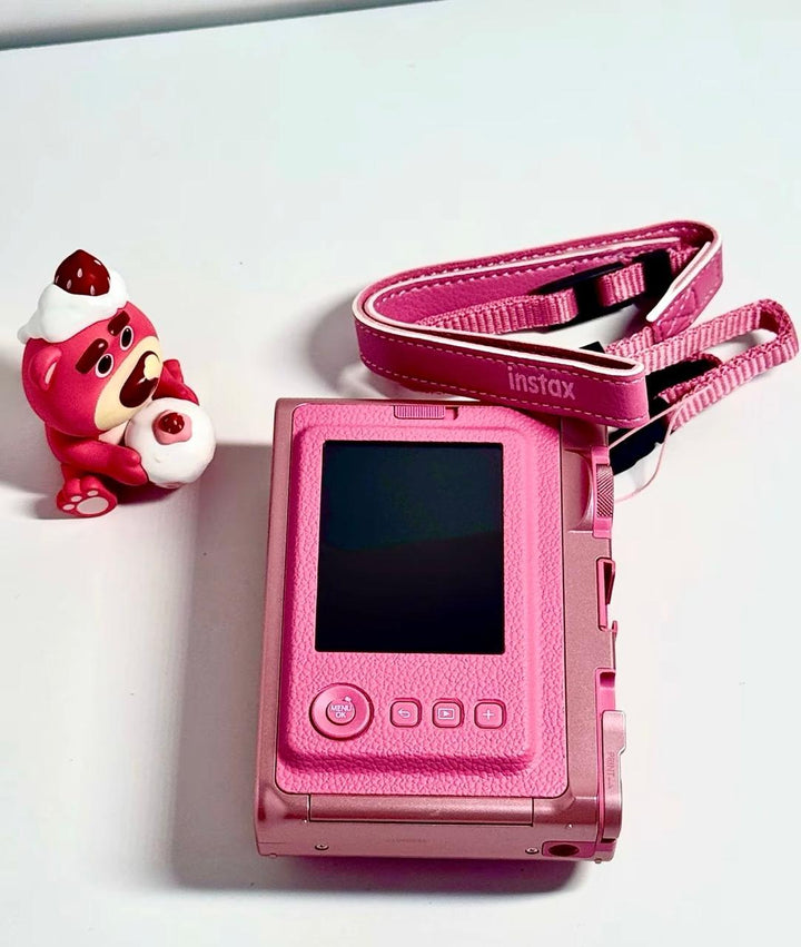 كاميرا فورية هايبرد FUJIFILM Instax Mini Evo بإصدار وردي خاص مع حزام وتصميم أنيق.