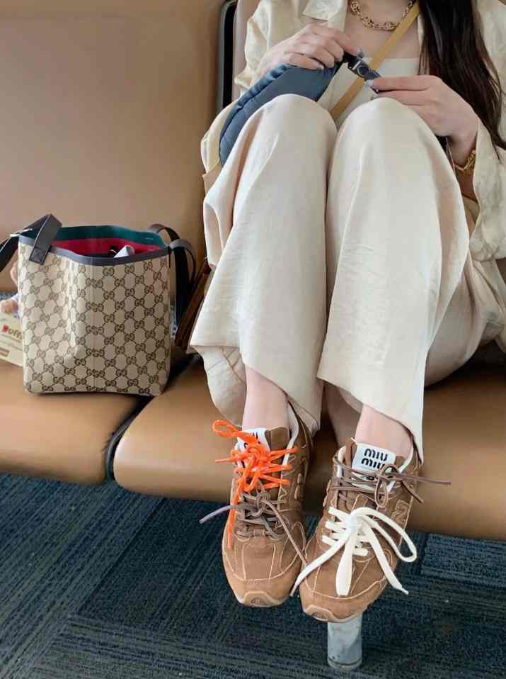 New Balance x Miu Miu suede sneakers with dual laces and iconic logo.