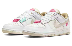 حذاء Nike Dunk Low رياضي باللون الأبيض والوردي.