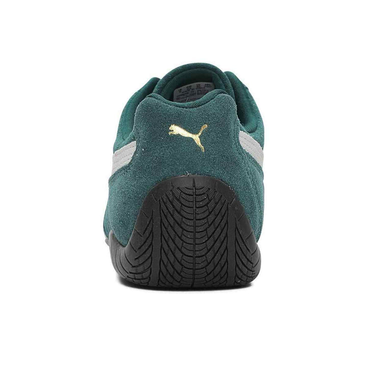 Puma Speedcat OG sneakers in green suede with black rubber sole and gold logo detailing.