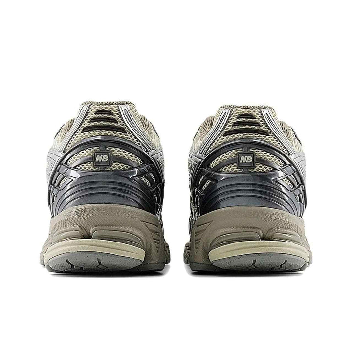Rear view of beige New Balance 1906R sneakers with silver accents and cushioned sole
