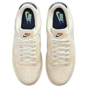 حذاء Nike Dunk Low بتفاصيل عاكسة للضوء لون كريمي.