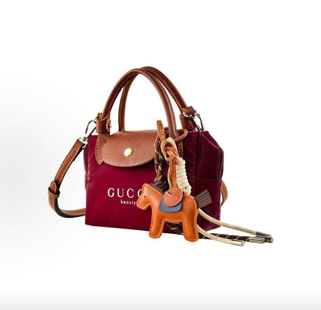 حقيبة يد GUCCI beauty صغيرة بلون عنابي مع تعليقة.